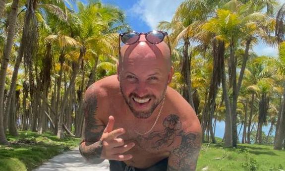 Musician Chase Rideman, in palm tree forest, smiling