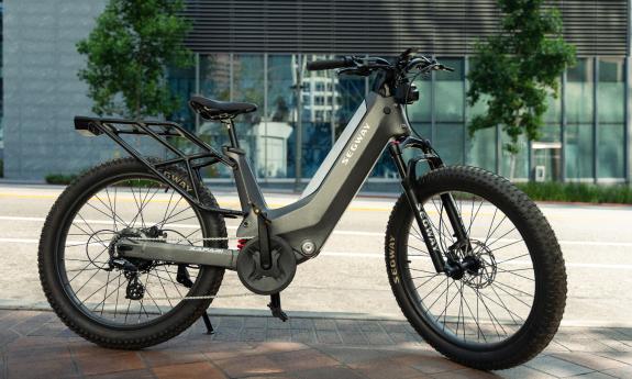 A Segway e-bike standing in front of a grey and glass building