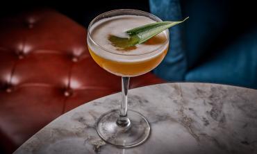 A craft cocktail topped with a garnish