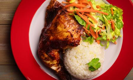 A quarter chicken with white rice and a salad
