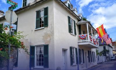 The street view of Ximenez-Fatio house festooned with bunting and flags on a sunny day